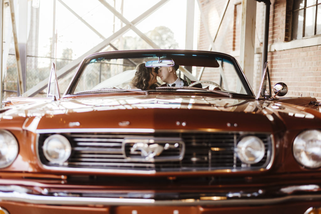 Bride and Groom in vintage convertible Mustang